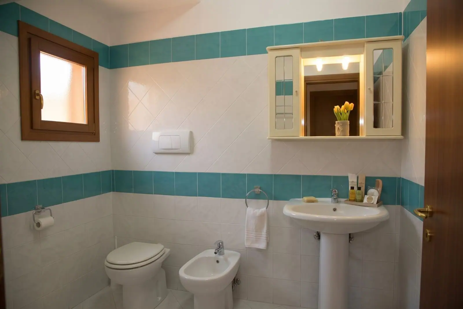 Bagno con finestra, lavabo e mobile a specchio, La Casa in Sardegna